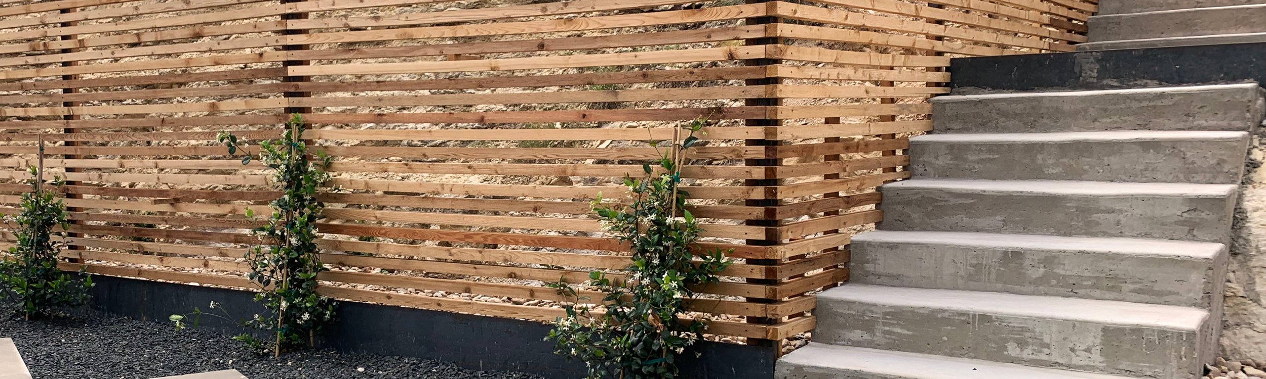 Clean-lined privacy fence framing a low-maintenance Westlake Hills backyard with gravel and stepping stones