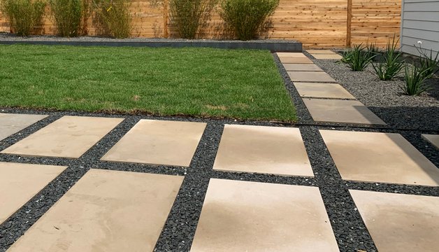Modern Westlake Hills terrace with healthy sod, gravel, and planting beds