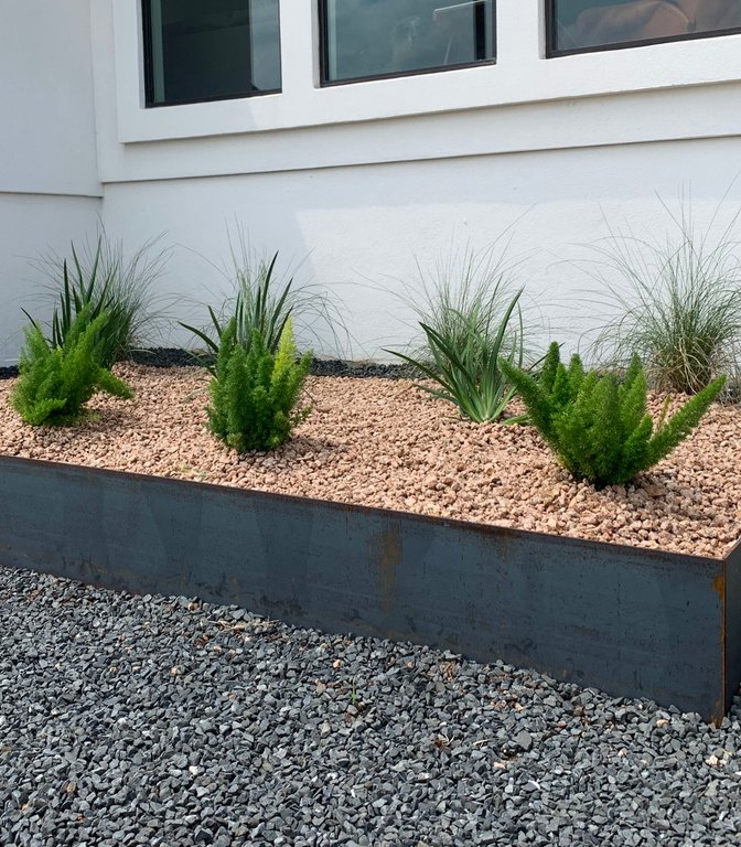 Westlake Hills xeriscape with a steel-edged gravel planter bed and ornamental plants