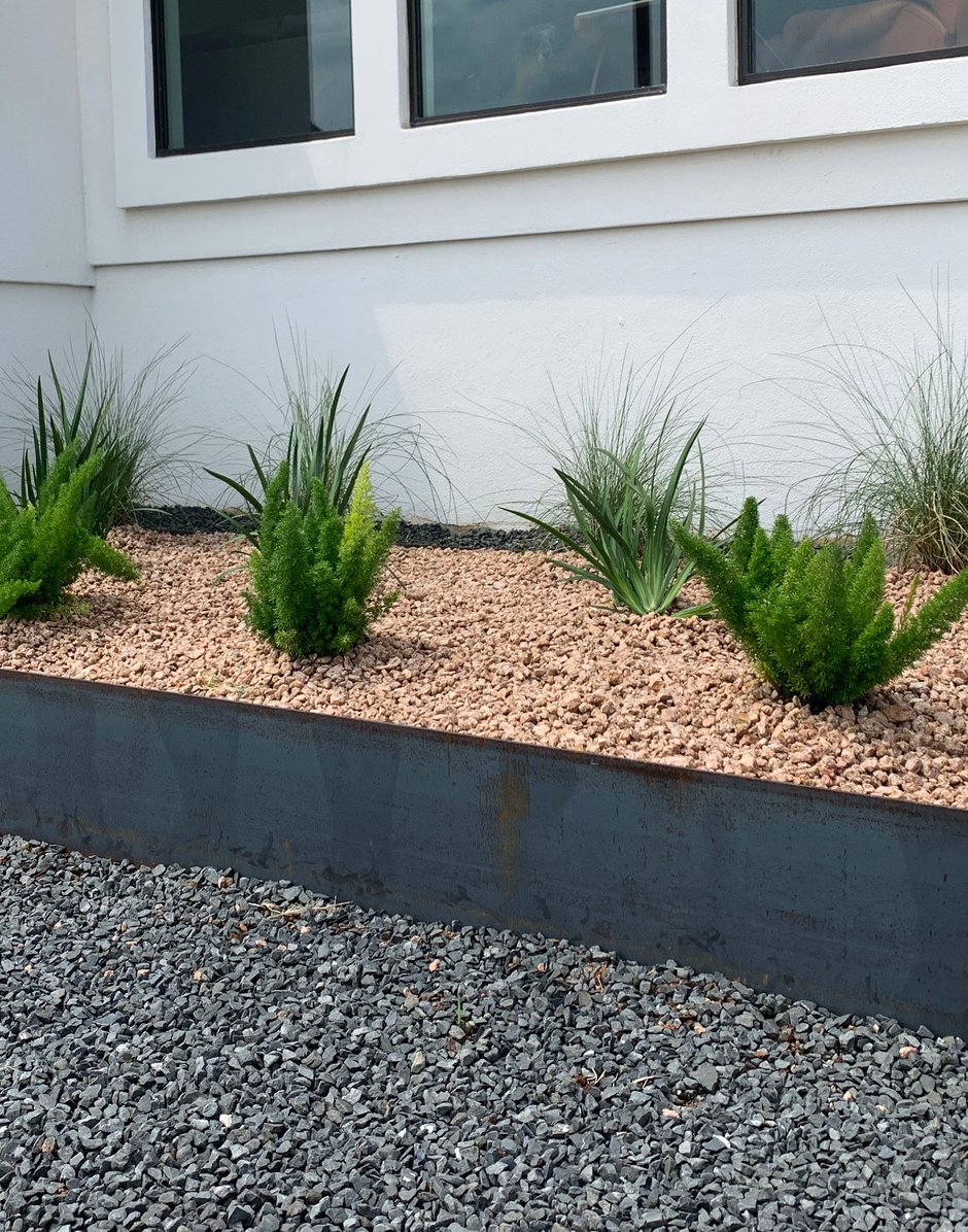 Steel-edged planter bed with gravel and ornamental plants