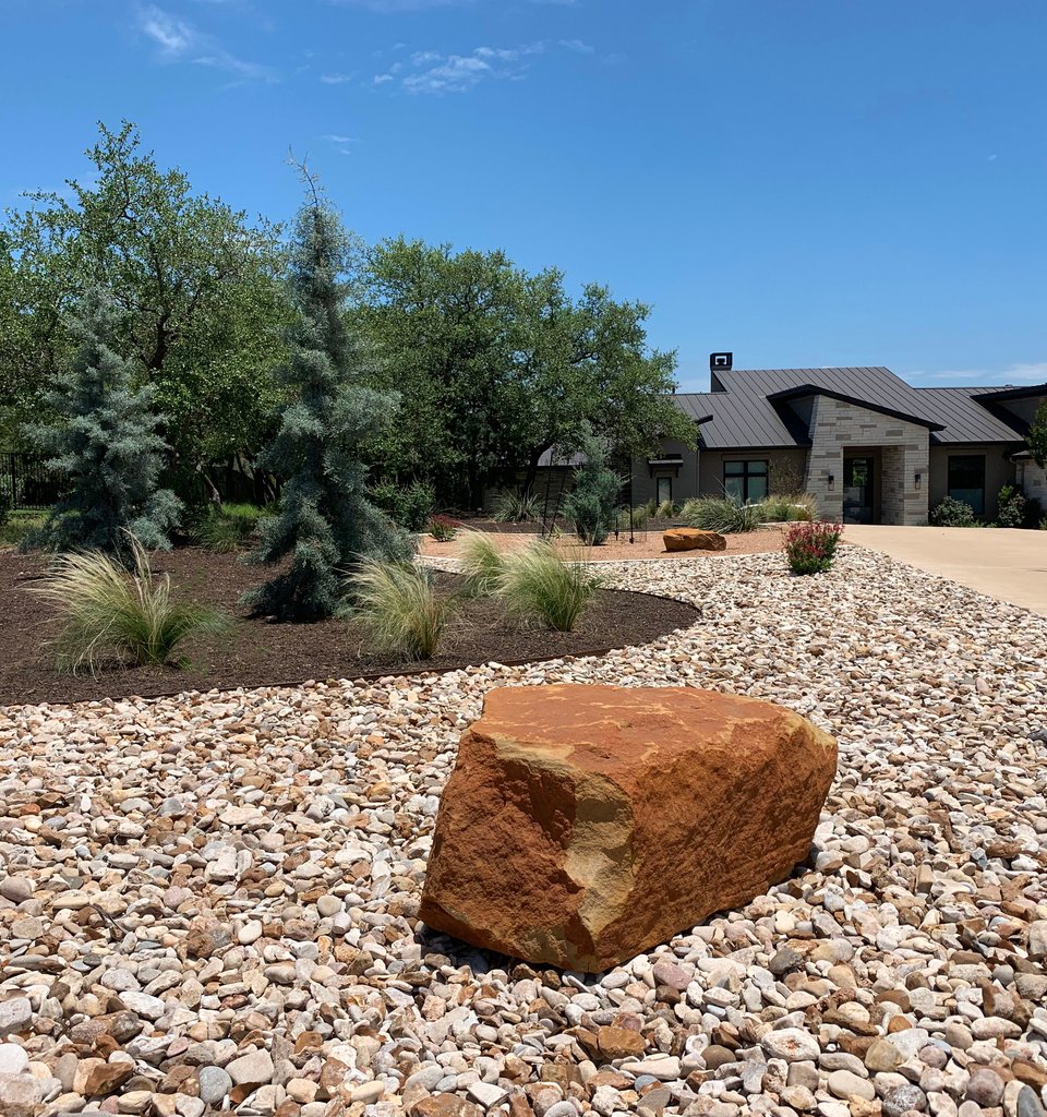 Dripping Springs Hill Country yard with river rock and gravel channels that move runoff